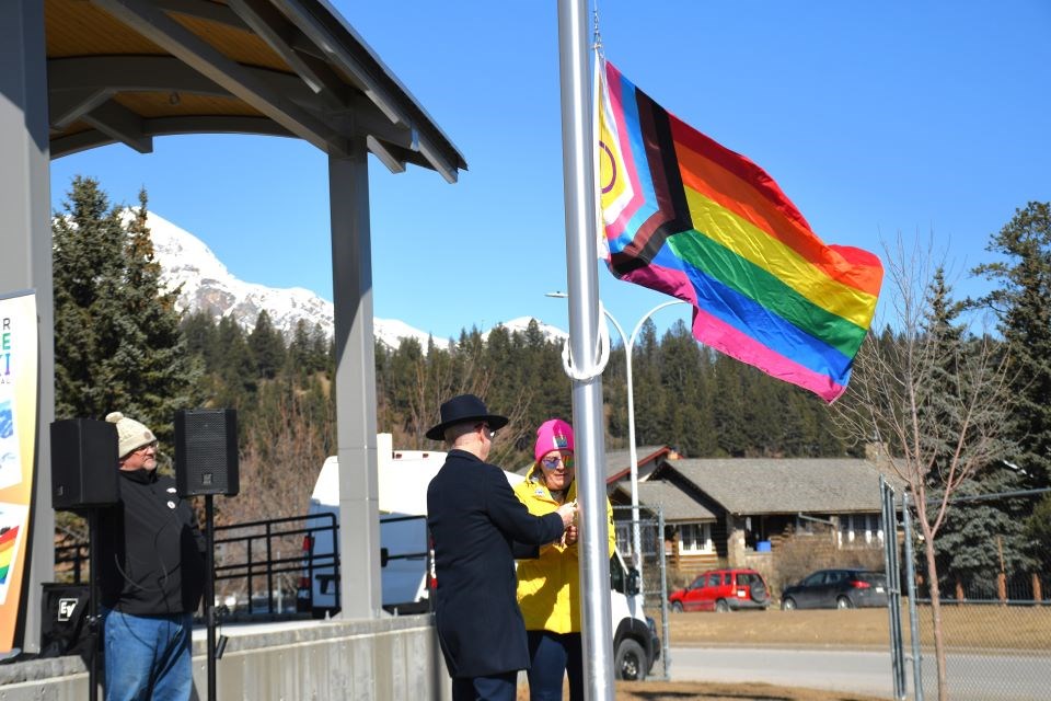 Jasper Mayor Richard Ireland and Mollie Lalonde-Lynch with the Jasper Pride and Ski Festival raise the Pride flag at Commemoration Park on Friday, April 4, 2025.