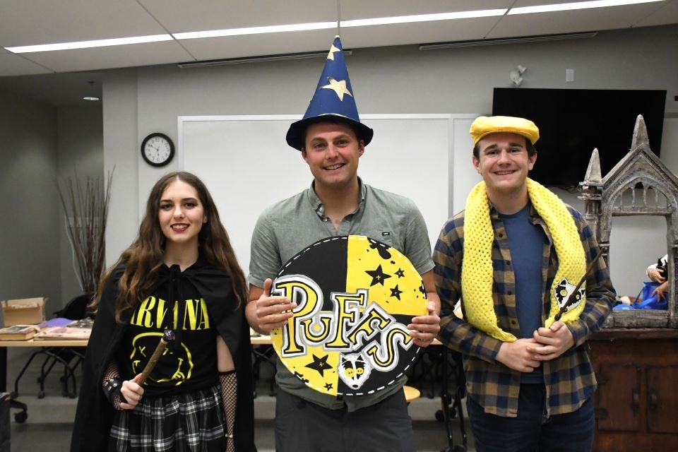 From the left: Co-directors Adelle Riopel, Thayne Harden and Emerson Gibbons with Jasper Acts pose with props just before a rehearsal of "Puffs" at the Library and Cultural Centre in Jasper, Alta. on Friday, April 25, 2025.