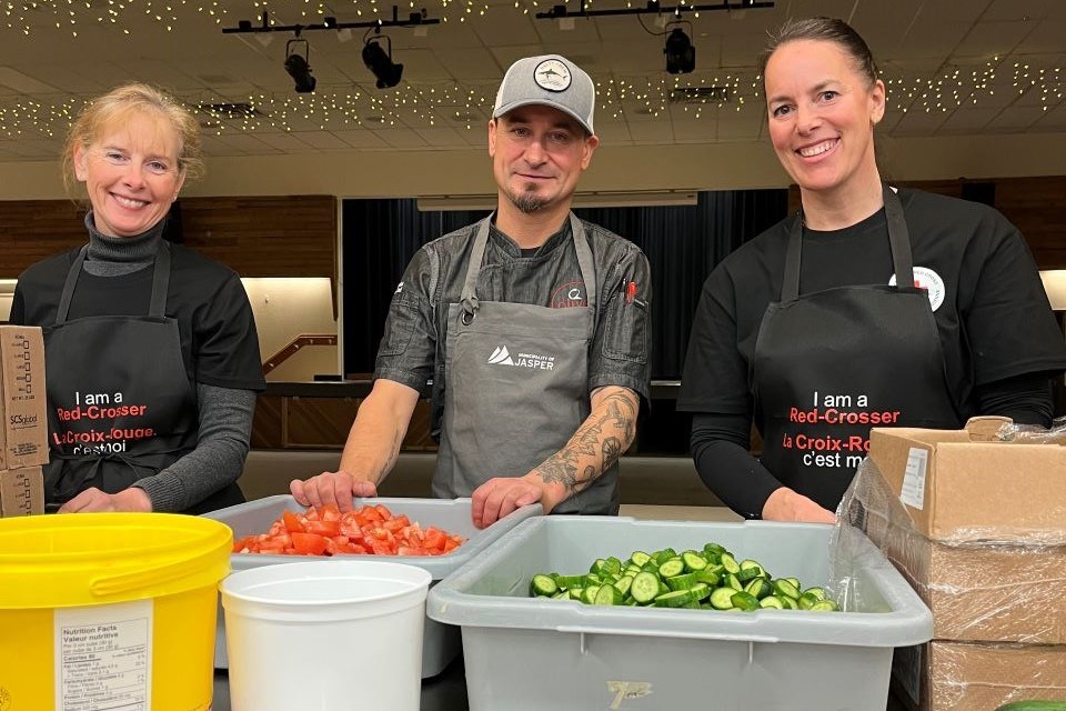 From the left: Janet Johnson, Canadian Red Cross chief development officer; Darryl Huculak, Jasper Community Dinner co-ordinator and chef/owner of Olive Bistro; and Melanie Soler, vice president of relief operations preparing food for the Community Dinner in Jasper, Alta. on March 30, 2025.