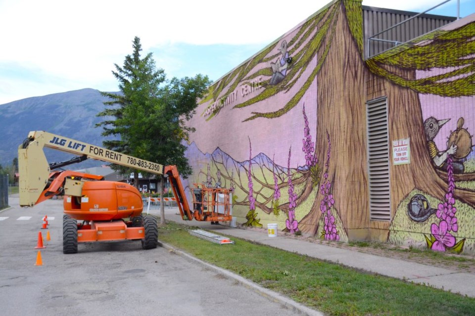 Belgian artist Gijs Vanhee paints a mural on the side of the Jasper Activity Centre on Sunday, Aug. 10, 2025.