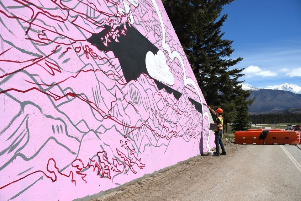 Tyler Toews completes his mural at the east entrance to town in Jasper, Alta. on Thursday, May 16, 2025.