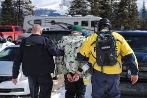 Const. Devon Slade escorts an intoxicated skier to an RCMP squad car. P. Clarke photo