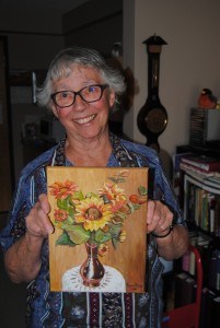 Agnus Hisey holds one of her many paintings she has completed since 2008. Photo - P. Clarke. 