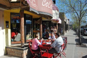 Coco’s Cafe had its bright red tables and chairs outside on May 20. Photo - P. Clarke. 