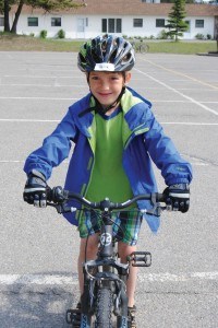 The children road their bikes around the Activity Centre parking lot to practice their hand signals. Photo - P. Clarke. 