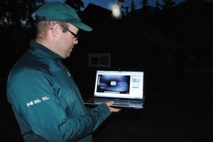 Kevin Gedling, a partnering engagement officer for Parks Canada, looks at a live video feed of bats roosting at the Palisades Stewardship Education Centre. Photo - P. Clarke.