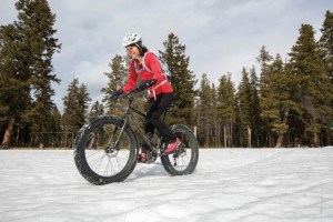 A woman fat bikes along a snowy path at Lake Annette