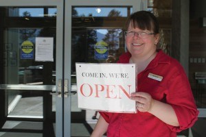 Angie Thom, director of library services, was all smiles when she filed the open sign for the first time at the Library and Cultural Centre, June 28. Photo - K,. Byrne. 
