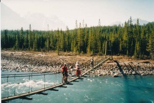 Sandy Cox, Vonna Aresnault and Don Cackette ride their bikes across the Athabasca River in 1993. K. Byers photo. 