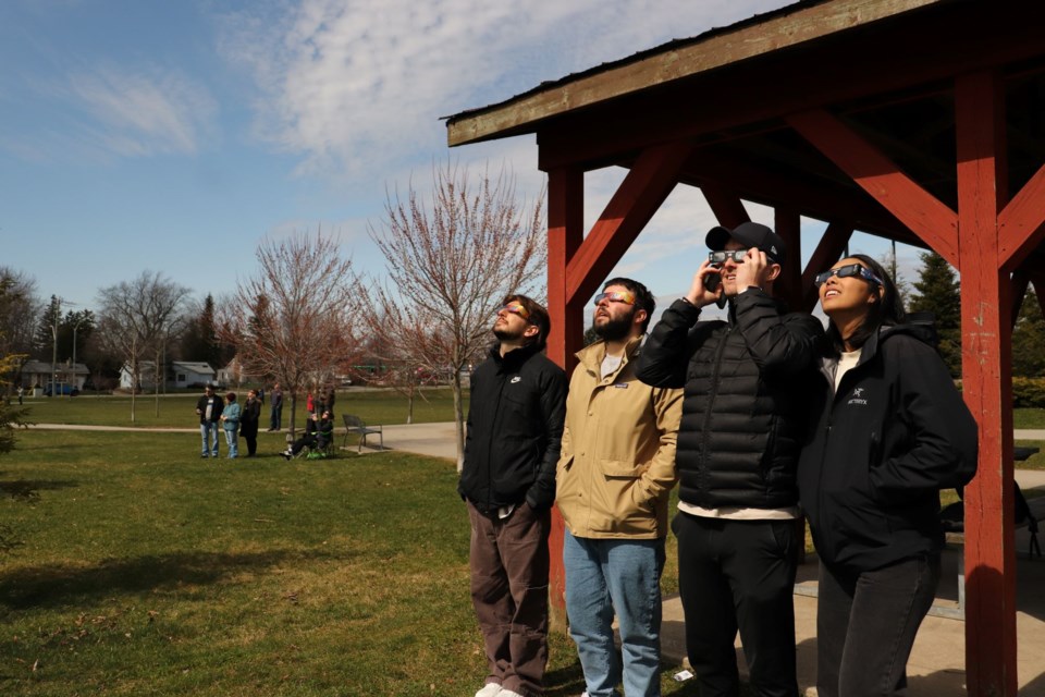 Justin Maciel, James Fudurich, Dustin McDonald and Amp Pettawee view the eclipse at the pavillion in Memorial Park. The foursome drove from Toronto to watch the eclipse. 