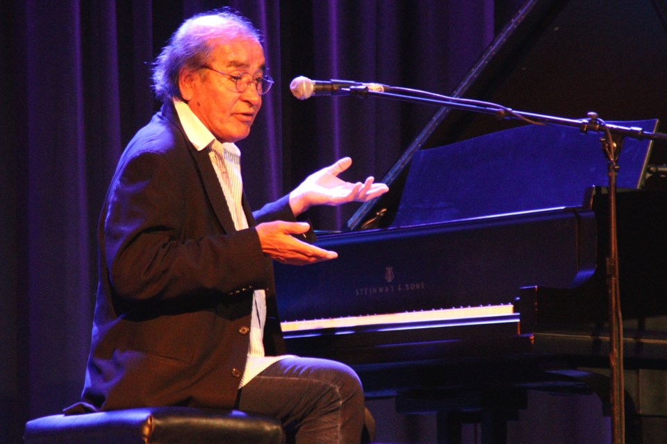 Acclaimed writer and pianist Tomson Highway speaks to the crowd while seated at the Steinway piano during his appearance at the R.H. Channing Auditorium Oct. 14.