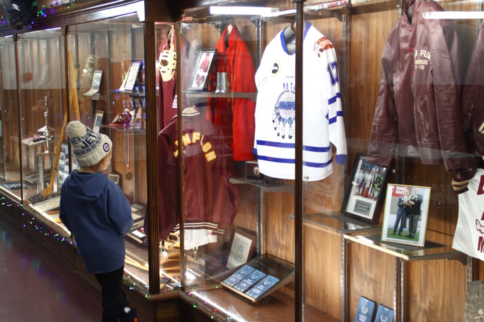 A youngster checks out the new items in the Whitney Forum memorabilia chest, located in the rink's lobby.
