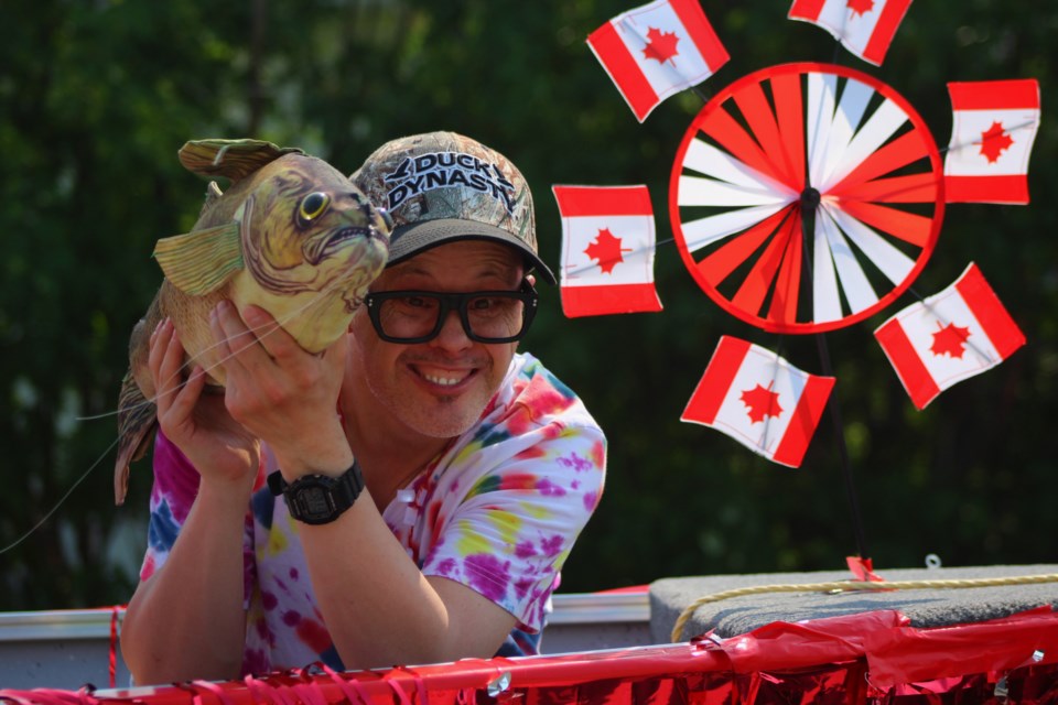 Stacey Madland hoists a fish up from a parade float during the Trout Festival Canada Day parade.