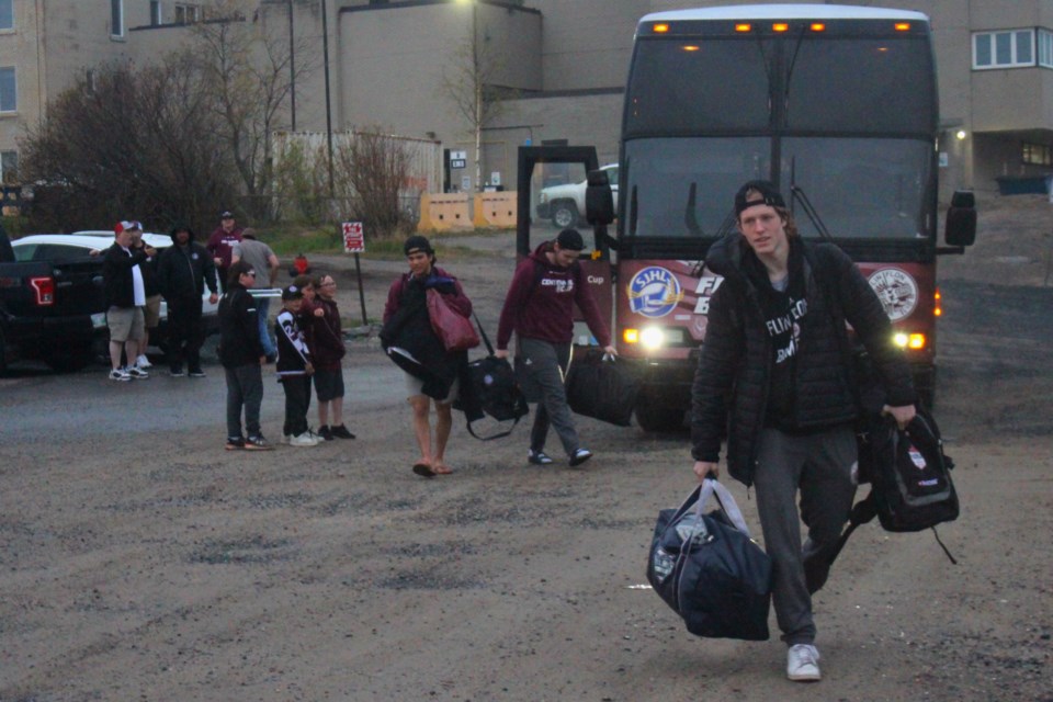 Jacob Vockler takes his gear away from the team bus while fans cheer players on during the team's arrival at the Whitney Forum May 28.