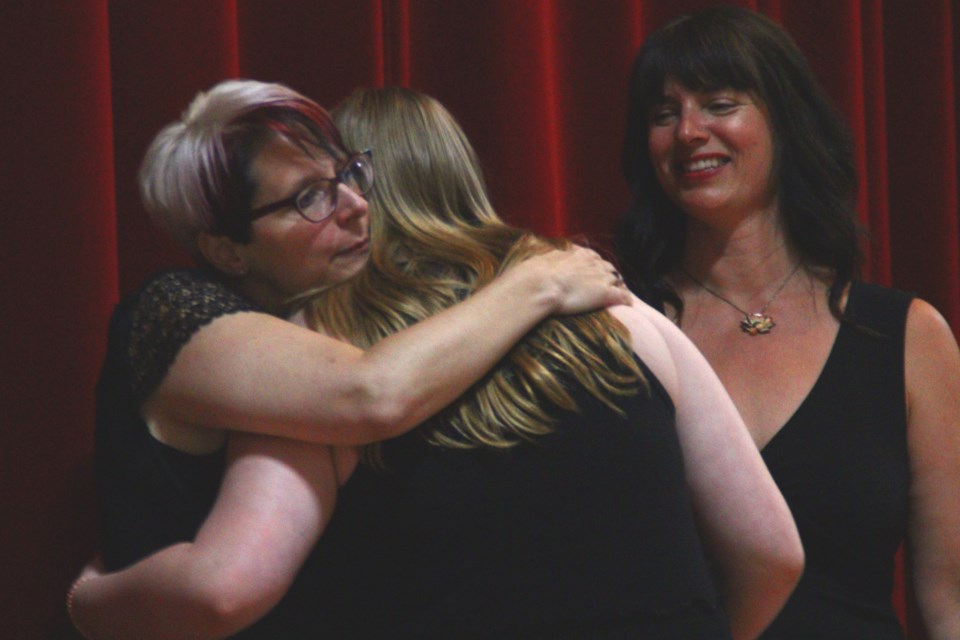 Laura Clark-Watt hugs her daughter Genevieve while giving her an award for Hapnot's junior varsity basketball team during the school's annual awards banquet.
