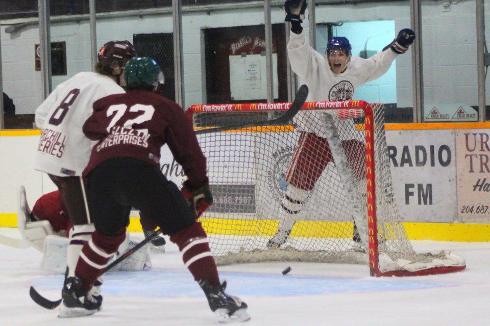 Team White’s Nathan Gagne and Jeremi Tremblay (right, behind net) celebrate Gagne’s goal in Bombers’ maroon and white game Sept. 4.