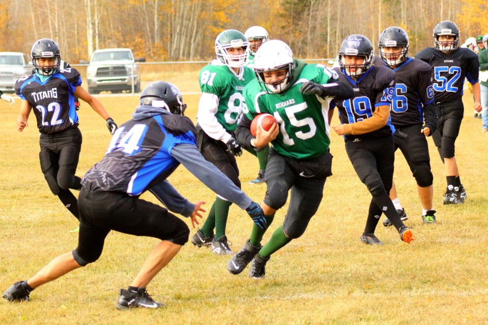 Kodiaks quarterback Marcus Kennedy runs the ball around Ahtahkakoop Titan Luke Ahenakew during the teams' Oct. 13 game in Creighton.