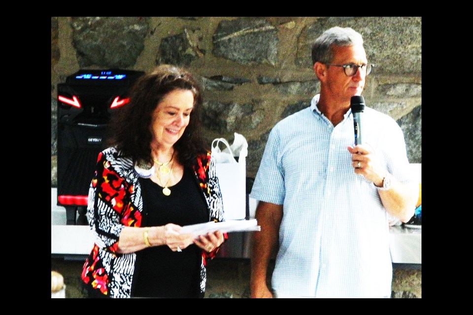 Tricia O'Hara, left, and upcoming Optimist Club of Arlington president Brian Kellenberger lead the raffle giveaway at the Coaches Night Out event.