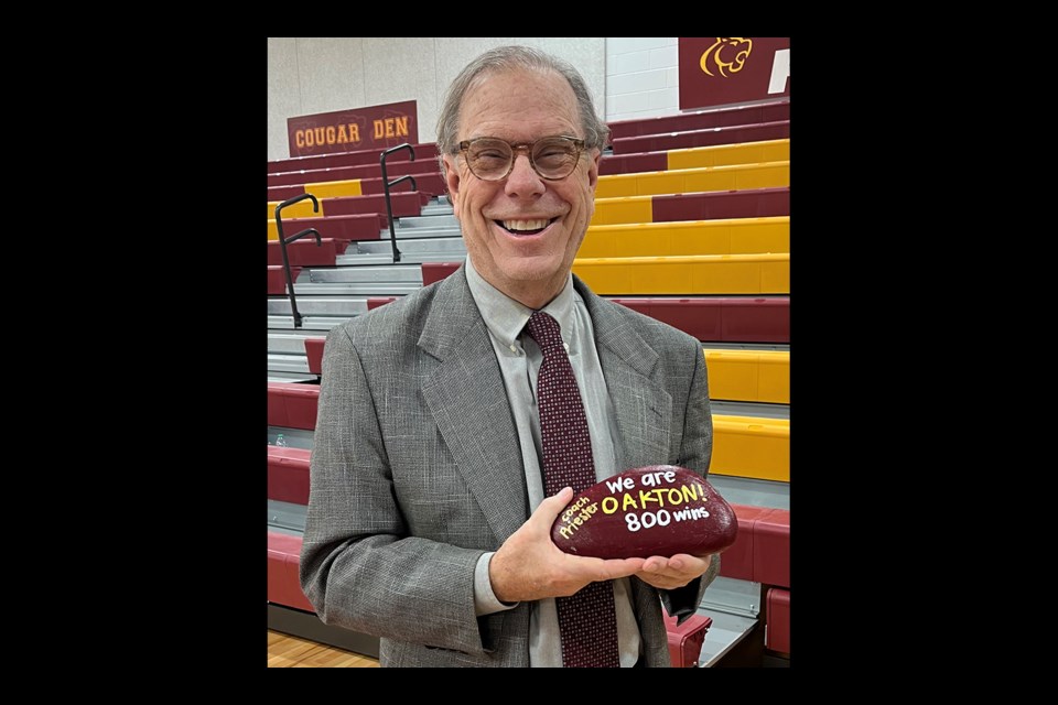 Oakton coach Fred Priester holds a traditional Oakton rock after winning his 800th career game.