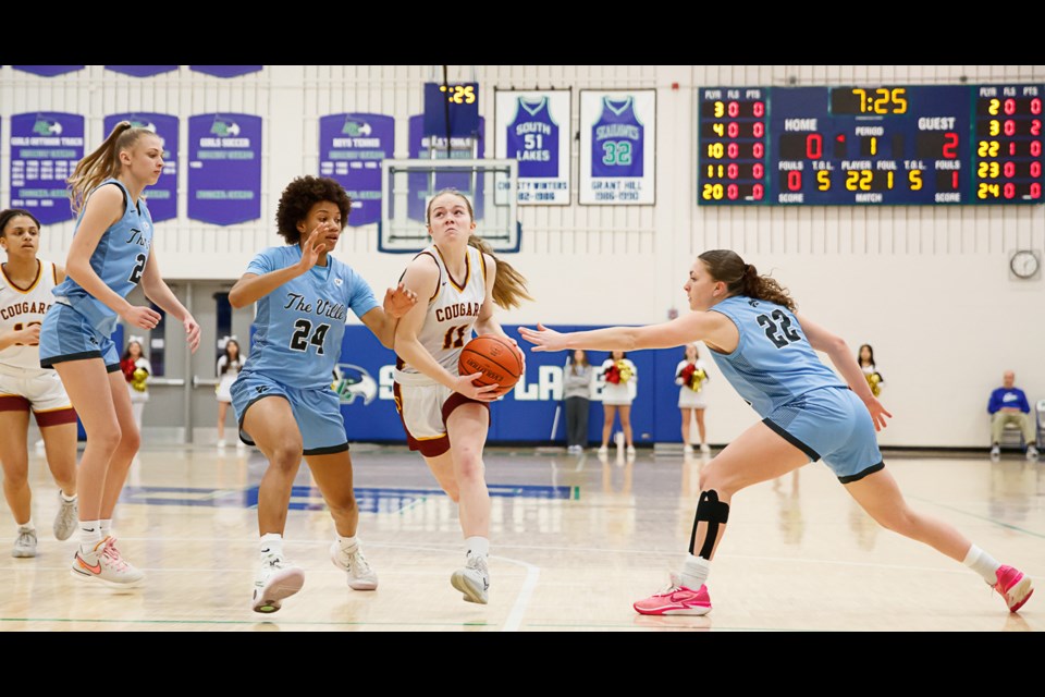 Oakton's Sophie Toole fights her way into the lane as she is defended by Kennedy Parrott and Hannah Wakefield of Centreville.