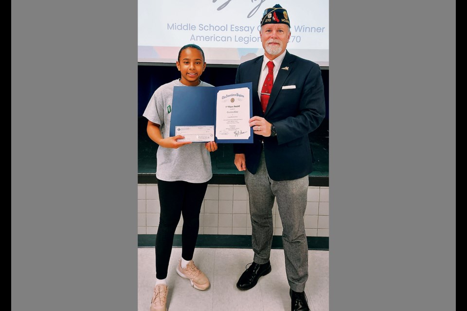 Cooper Middle School seventh-grader Caroline Gray poses with Tony Sarver of American Legion Post 270 in McLean after taking first prize in the post's Middle School Essay Contest. 