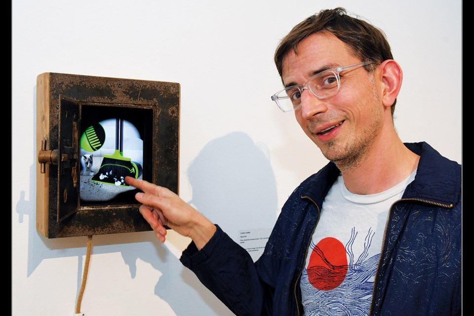 Artist Chris Combs, whose works now are on display at the McLean Project for the Arts, demonstrates how his artwork "Black Box" allow viewers to unveil images by moving their fingers in front of sensors. 