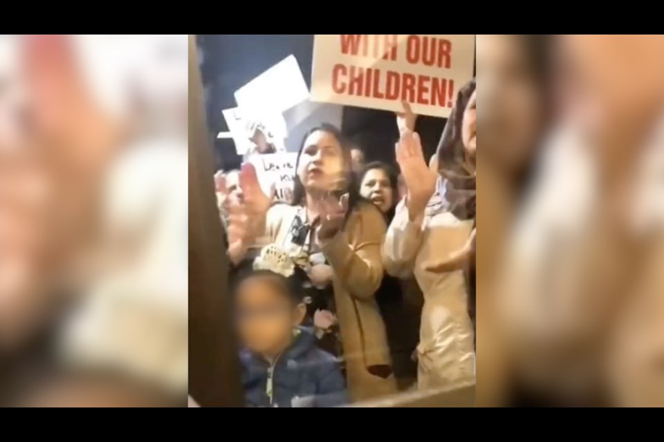 A young child and mother gather outside the Abbotsford School District's board office to protest SOGI on Sept. 26, 2023. 