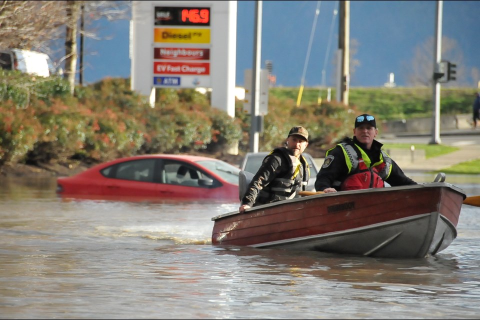 A rescuer works to ferry people over floodwaters near Highway 1 and Whatcom Road, Sumas Prairie, Abbotsford.