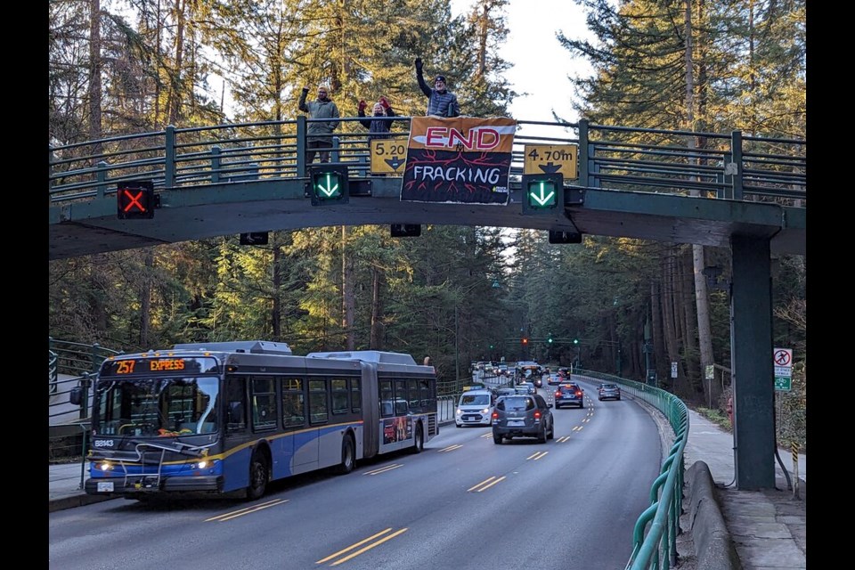 One of several groups against fracking for natural gas drop a banner over traffic through Stanley Park in Vancouver, B.C., Monday, March 27, 2023.