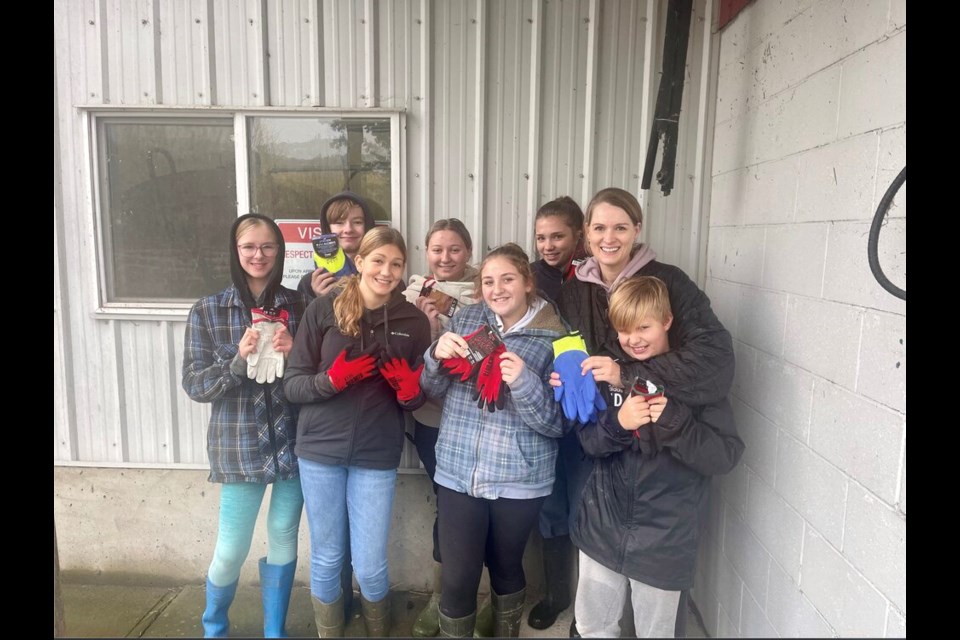 A group of happy Sumas Prairie neighbours show off new gloves. After cold weather set in, people are most desperate for warm clothing and heaters.