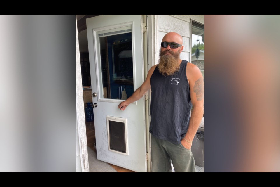 Ucluelet homeowner Brandon Halvorson stands beside the dog door a bear used to enter his house around July 17 or 18.