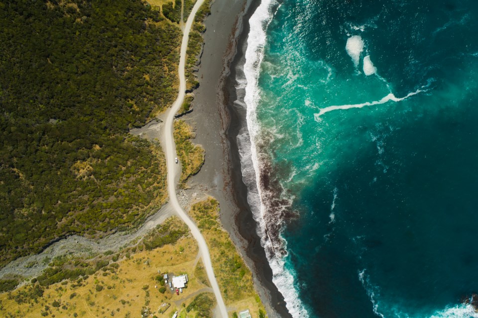 Aerial view of road passing next to coast