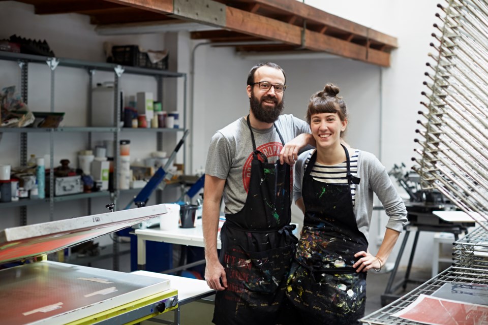 Two silk screen workers showing their workshop