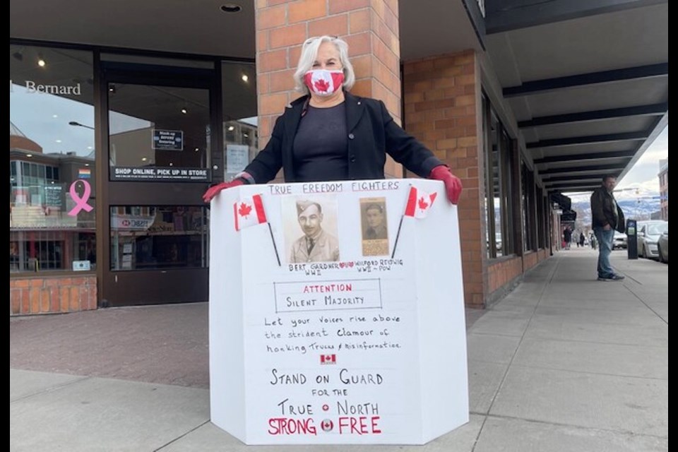 Sharon Gardner holds her solo counter-protest in downtown Kelowna Saturday.