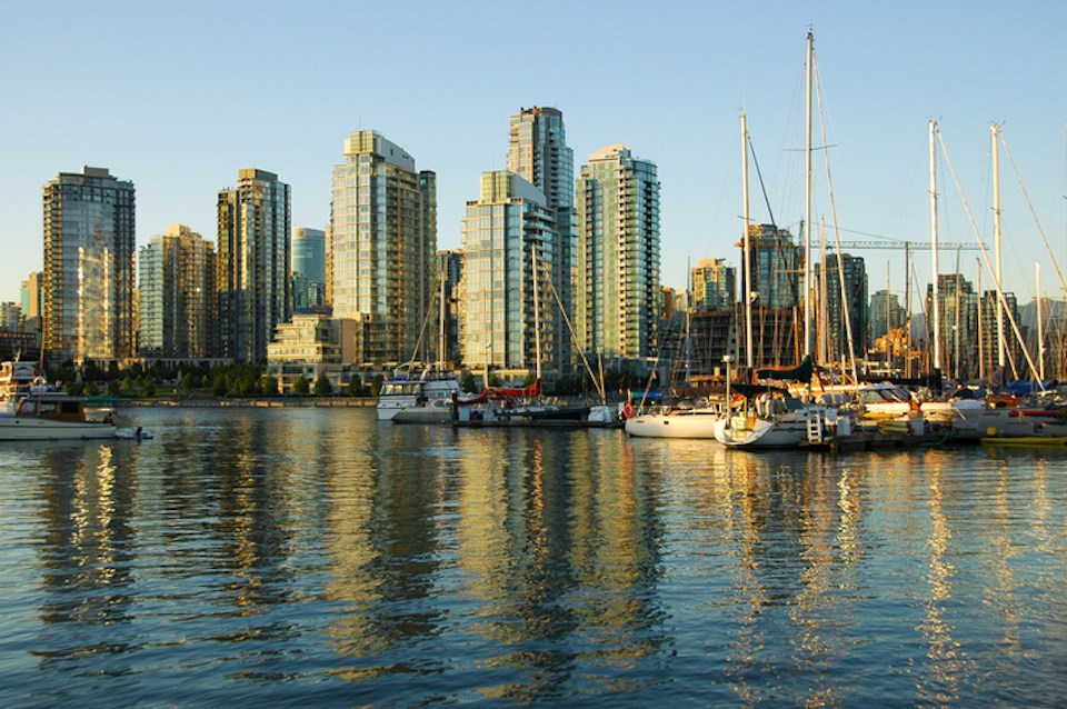 Sailboats and condominiums reflected by a calm inlet, Vancouver, British Columbia, Canada