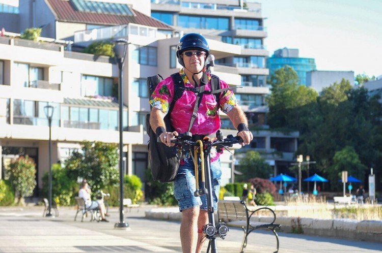 Musician Luis Fox of Vancouver, B.C., arrives at a weekly gig at a restaurant on the city's seawall. Fox says the scooter has transformed his daily commute into a pleasure. STEFAN LABBÉ/GLACIER MEDIA