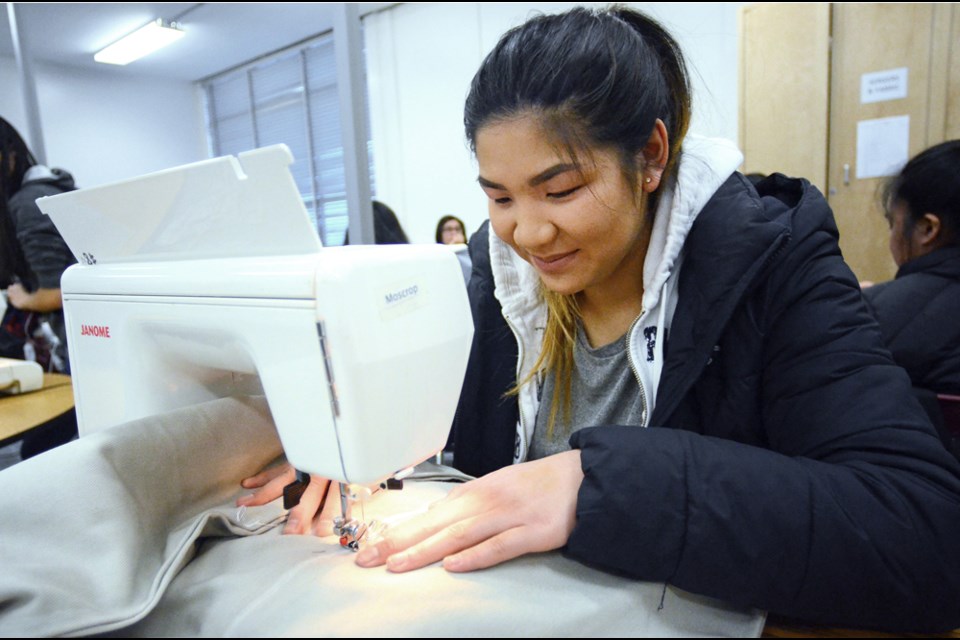 Moscrop textiles student Clarissa Wong sews a cage comforter for rescue dogs at the Burnaby SPCA.