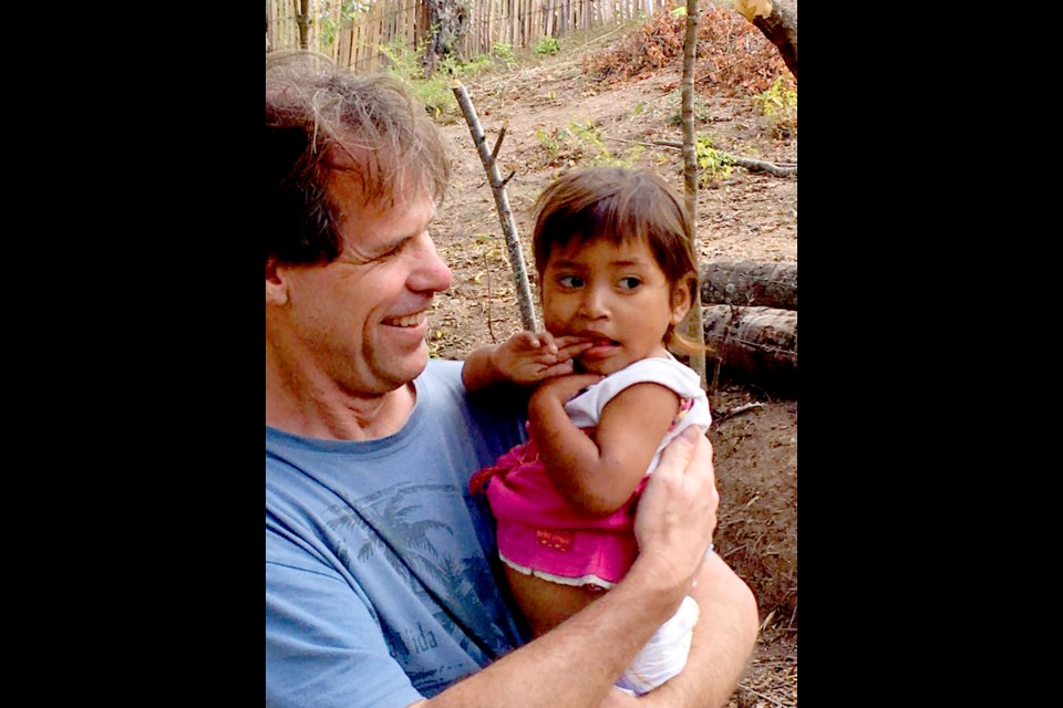 James Tuer holding a rescued orphan in the Hope of Life hospital. “They all have their arms stretched out just begging to be picked up and held,” he says.