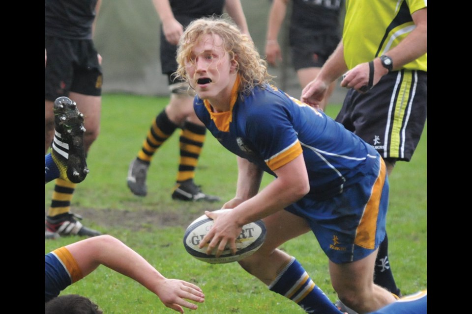 North Vancouver’s Cole Keffer looks through his long blond curls to find a teammate while playing for UBC against Capilano Rugby Club last season. On Sunday the multi-sport star shed his locks for charity. photo Paul McGrath, North Shore News