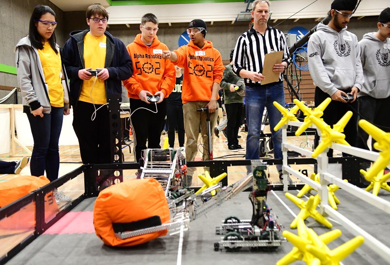 Alpha Secondary robotics students , from left in orange, Dylan McLean and Patrick Reddy put robot 502a through its paces at the VEX Robotics Pacific Northwest Regional Championships at BCIT Saturday.