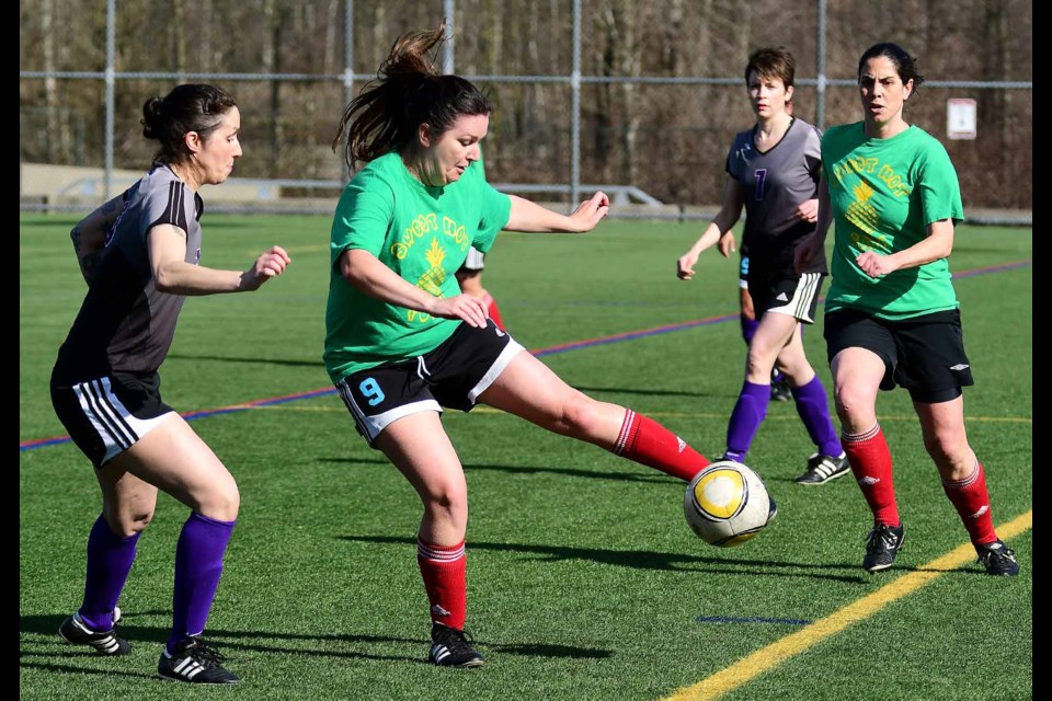 Poised and ready, the New Westminster Rush's Leni Burton, at left, and teammate Emily McLeod, in background, look to time their move against a Richmond Breakers ball carrier last week in the Metro Women's Soccer League Classics Div. 2 cup final.