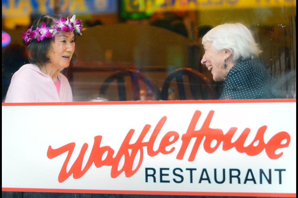 Susan Chew, left, and Verla (Staples) Thompson catch up during a surprise 90th birthday party for Chew at the Waffle House, a restaurant she founded in 1955. In 1956, the two former roommates were at the centre of a media fire storm about racism in the Royal City.