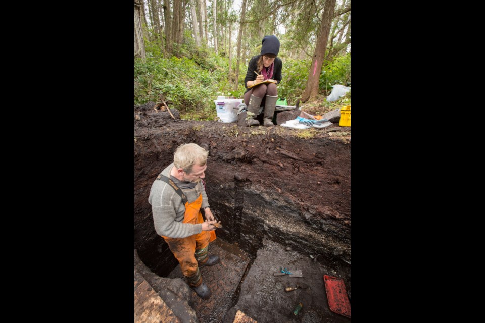 Alisha Gauvreau, a University of Victoria PhD student, takes notes as archeologist John Maxwell searches for artifacts in an excavation site on Triquet Island, where evidence of human habitation 14,000 years ago has been uncovered.