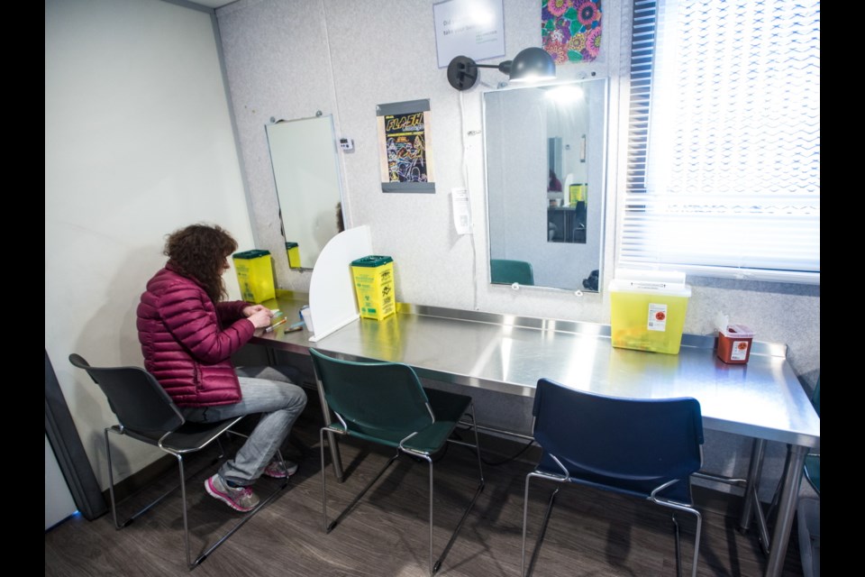 A heroin user prepares an injection in the overdose-prevention site at Our Place on Pandora Avenue. Island Health said new overdose-prevention spaces at the hotels will be less elaborate than the permanent sites such as the one at Our Place.