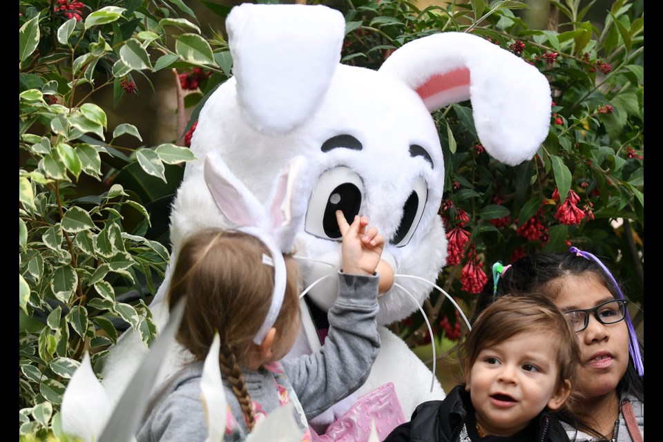 Nahla Navarro, 4, and Santos Navarro, 1 (centre), were among the many kids who visited with the Easter Bunnies at Queen's Park on Sunday.