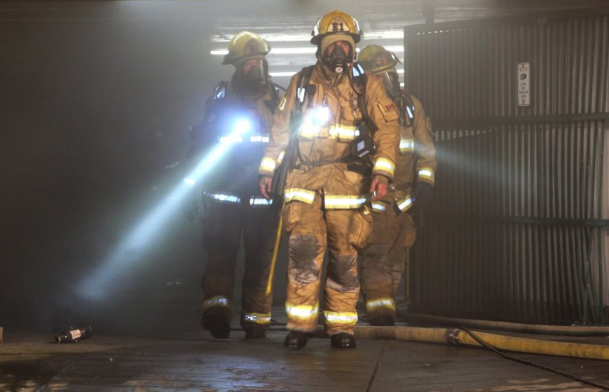 Burnaby firefighters exit an underground parkade at Burnaby Centre Apartments on Grange Street Thursday, where three cars were gutted by an evening fire.