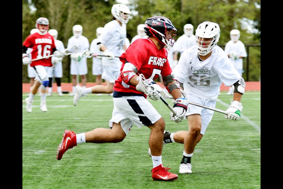 Burnaby native and SFU midfielder Jordan Lasher takes on an Oregon defender during Sunday's Pacific Northwest College Lacrosse championships at Terry Fox field.