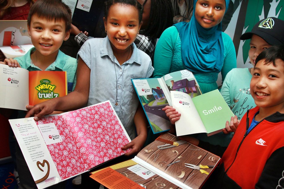 Children from Lord Kelvin Elementary School check out the new books in the United Way reading oasis.