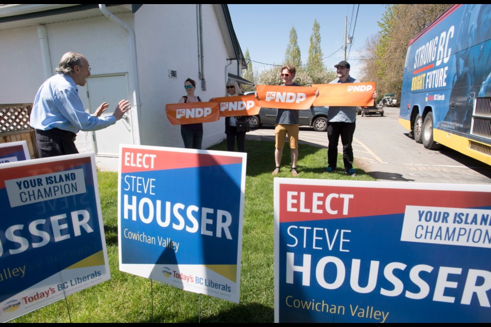 NDP supporters show up where B.C. Liberal leader Christy Clark was making a campaign stop at a farmers market in Duncan, B.C., Thursday, May 4, 2017.