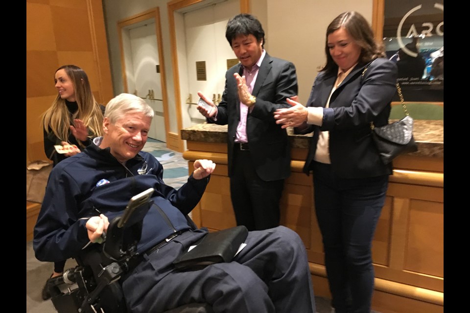 As he makes his way to the Liberal party's celebration in the ballroom of the Fairmont Waterfront in the early hours of May 10, Sam Sullivan is applauded for his win in Vancouver-False Creek. Behind him is campaign co-chair Kristen Blake.